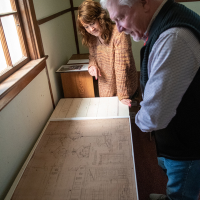 Ray Kapaun, nephew of Father Emil Kapaun, looking at architectural drawings of the building