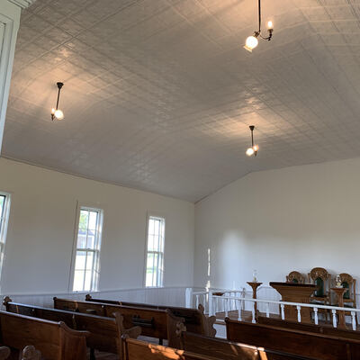 Church interior with lighting, tin ceiling and original furniture