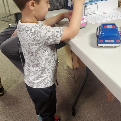 This little guy has found some cowboy boots and a toy.