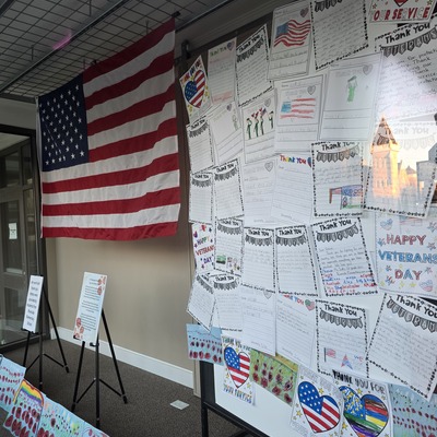 Veterans Day artwork and letters created by local students on display in the front windows.